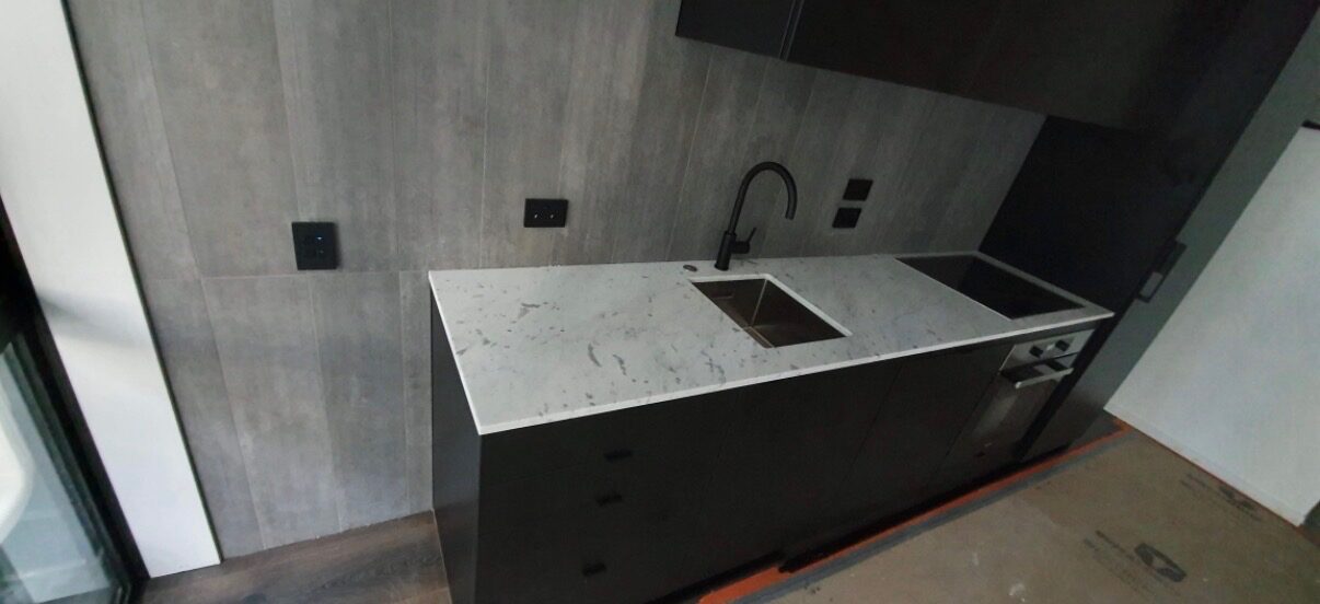 Complete luxury kitchen renovation in Auckland with stone island and brushed brass fixtures